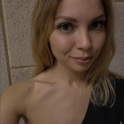 Woman with shimmering star makeup, silver hair accessories, and floral shoulder tattoo