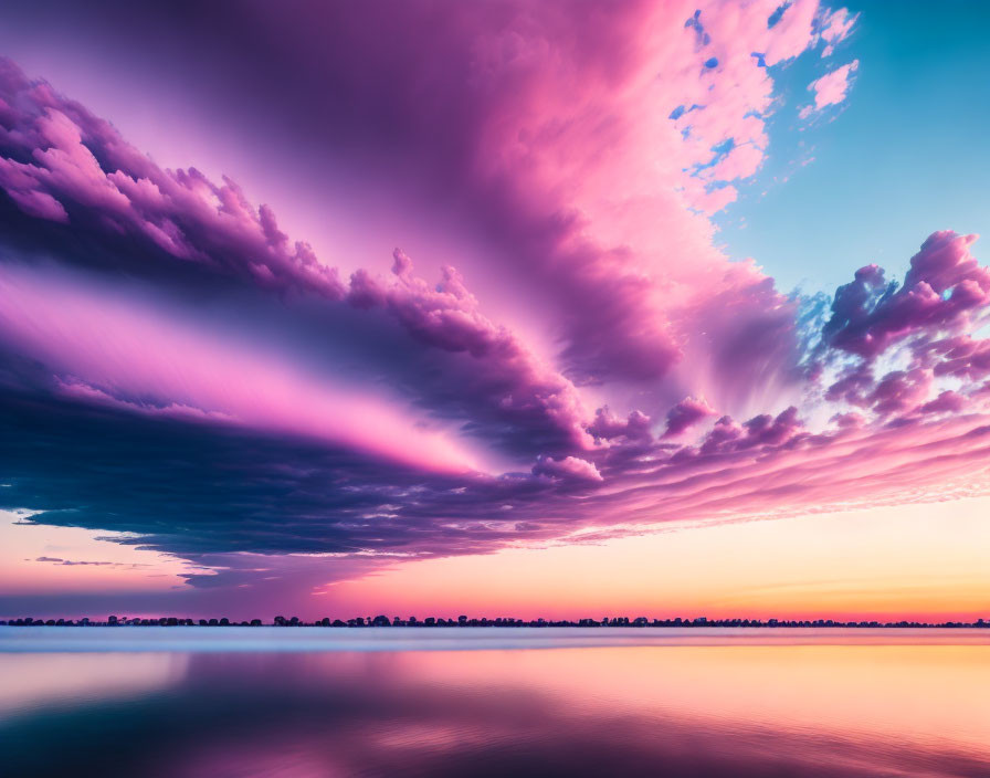 Colorful sunset with purple and pink clouds reflecting on calm water