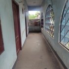 Balcony with potted plants, patterned tiles, small car, and blue fabric.