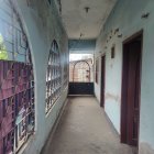 Elegant Victorian-style hallway with curving staircase, decorative railings, light blue walls, pendant light