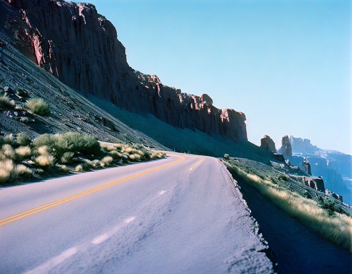 Desert landscape with winding road and rocky cliffs