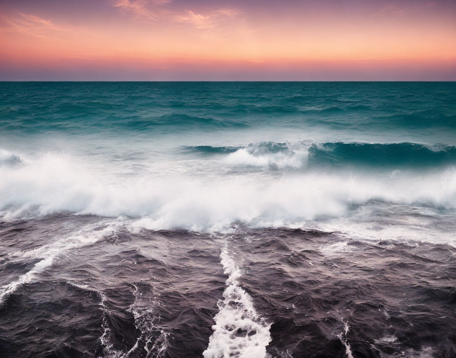 Turquoise waves meet dark waves under pink and blue sunset sky