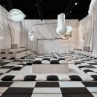 Surreal black and white checkered room with sculptural walls and glowing blue orb