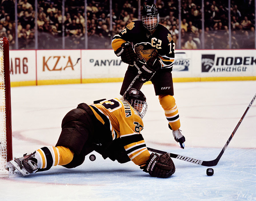 Hockey players in black and gold uniforms in action