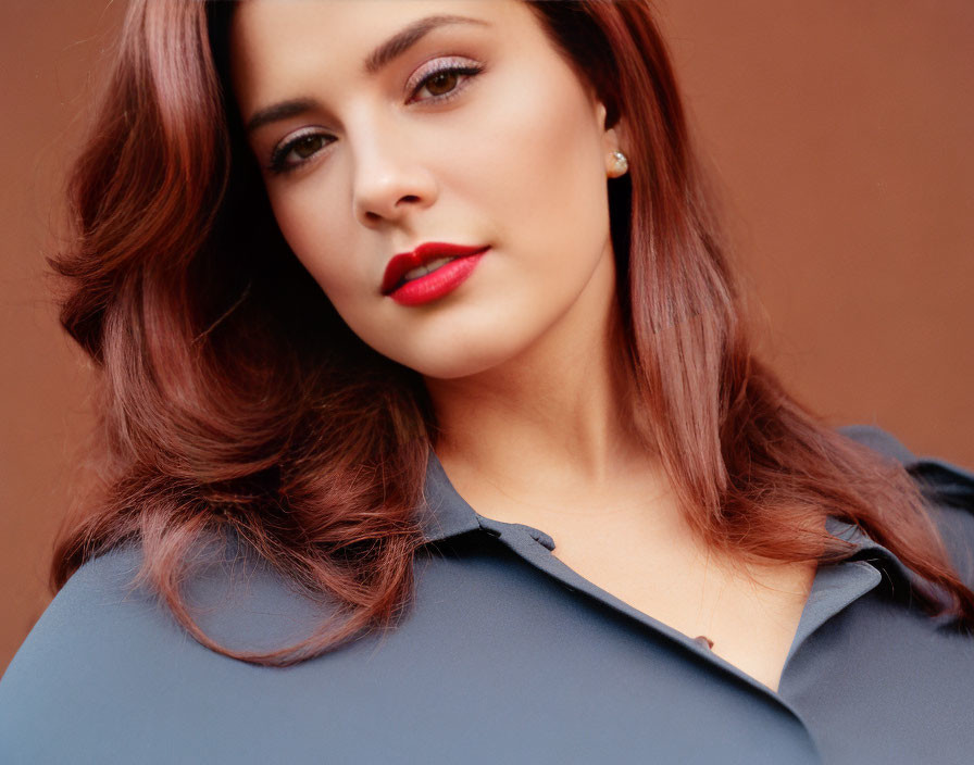 Portrait of a woman with voluminous brown hair and red lipstick