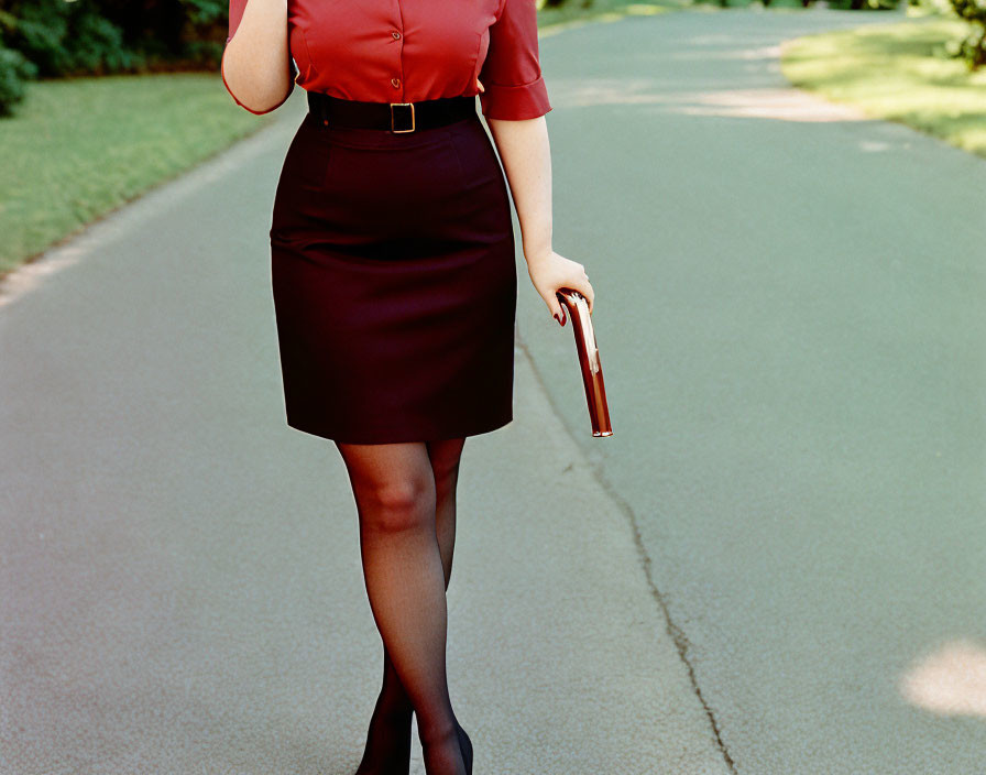 Woman in Red Blouse Holding Book on Pathway