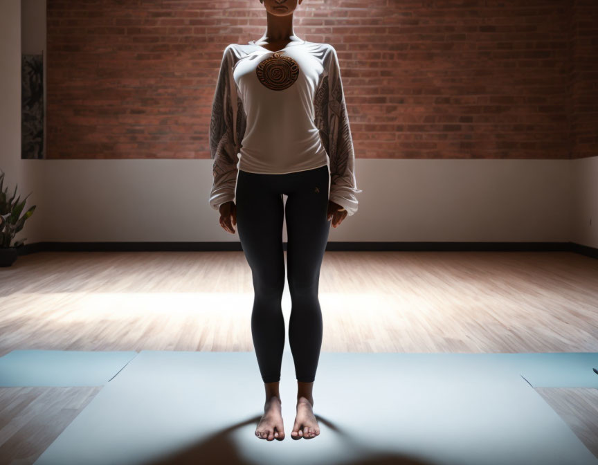 Yoga practitioner on mat in room with brick walls