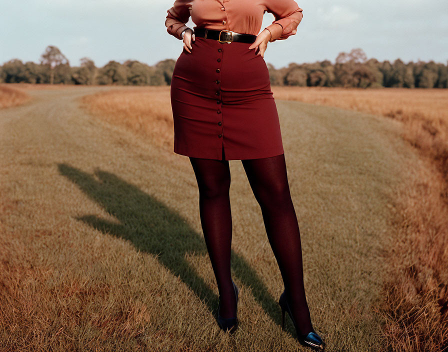 Person in Red Skirt and Black Tights Standing in Field