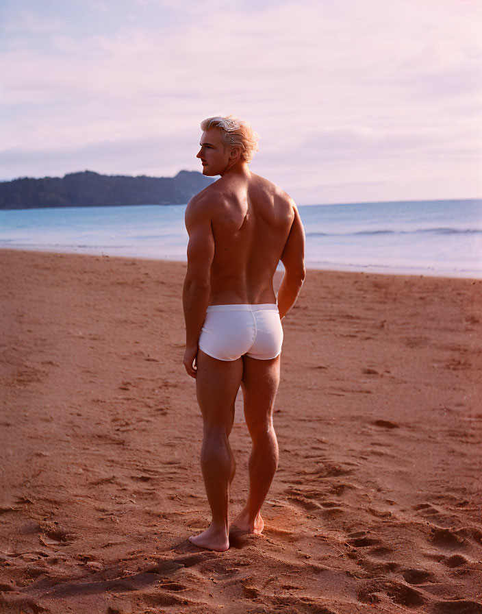 Blond Man in White Swim Trunks on Beach at Sunset