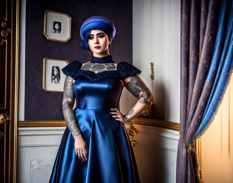 Tattooed woman in vintage blue dress in elegant room with portraits