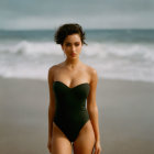 Woman in Black Swimsuit on Beach with Waves and Styled Hair