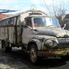 Futuristic metallic truck with tubular structures in urban setting.