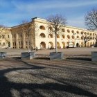 Baroque architecture palace with gardens, statues, and people in period clothing