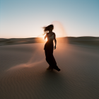 Woman in flowing dress stands in desert dunes at twilight