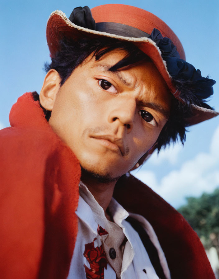 Man in Red Jacket and Hat with Feathers on Blue Sky