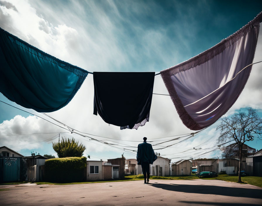 Person under hanging laundry with dramatic sky casting shadow