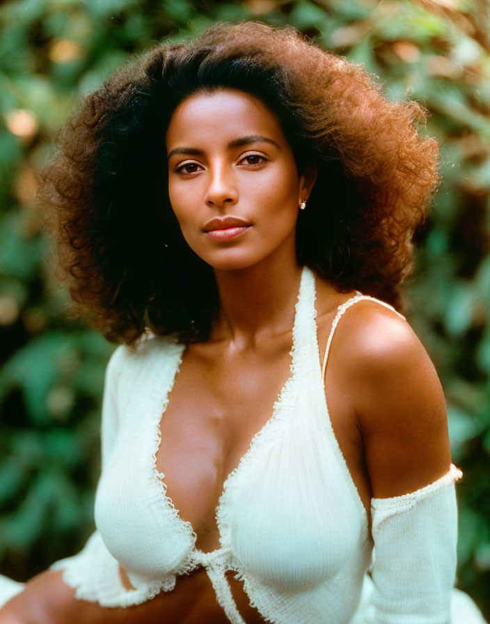 Curly-Haired Woman in Knit Top on Green Background