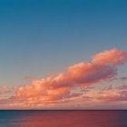 Tranquil seascape with pink and orange clouds over calm blue ocean