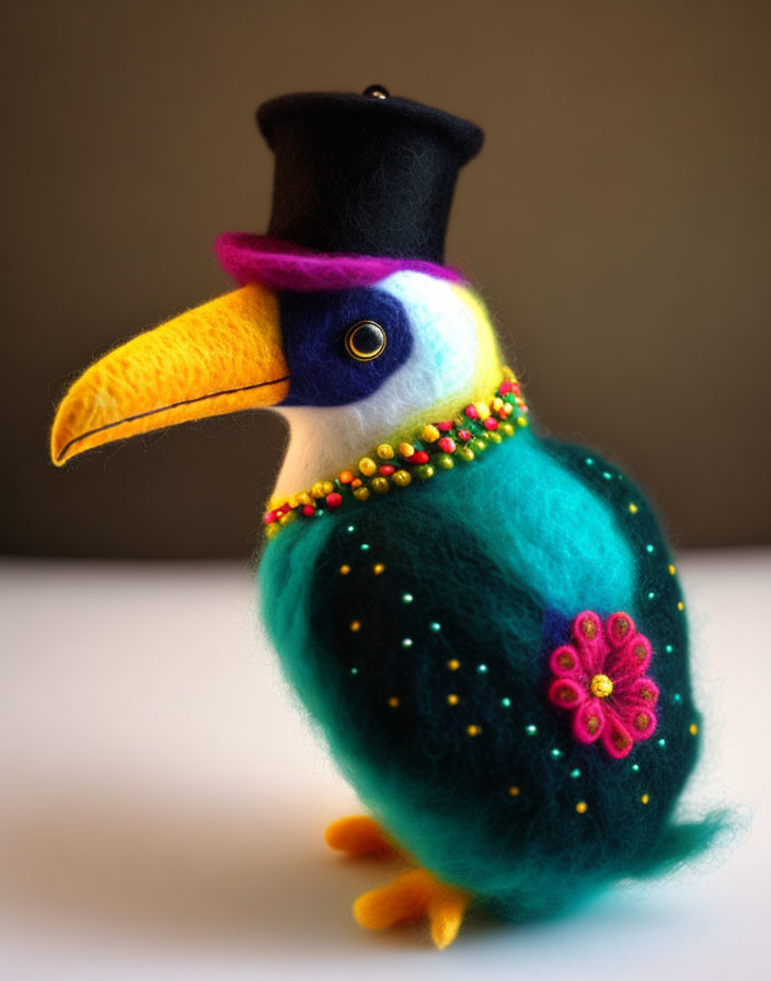 Colorful felt craft bird with top hat, beads, and floral patterns on gray backdrop