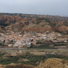 Traditional hilltop village with terracotta rooftops and church steeple in arid landscape