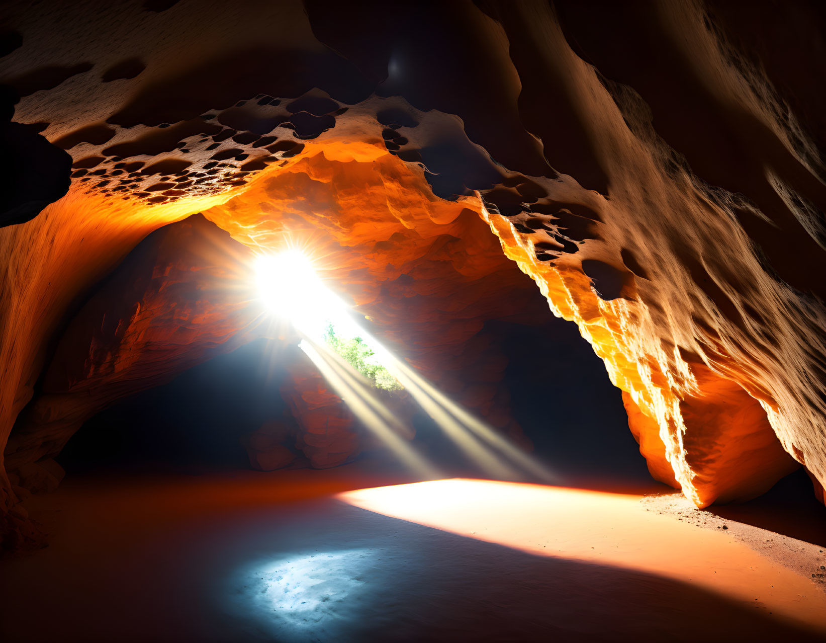 Sunbeam illuminates sandy cave floor in rocky, orange-hued cavern