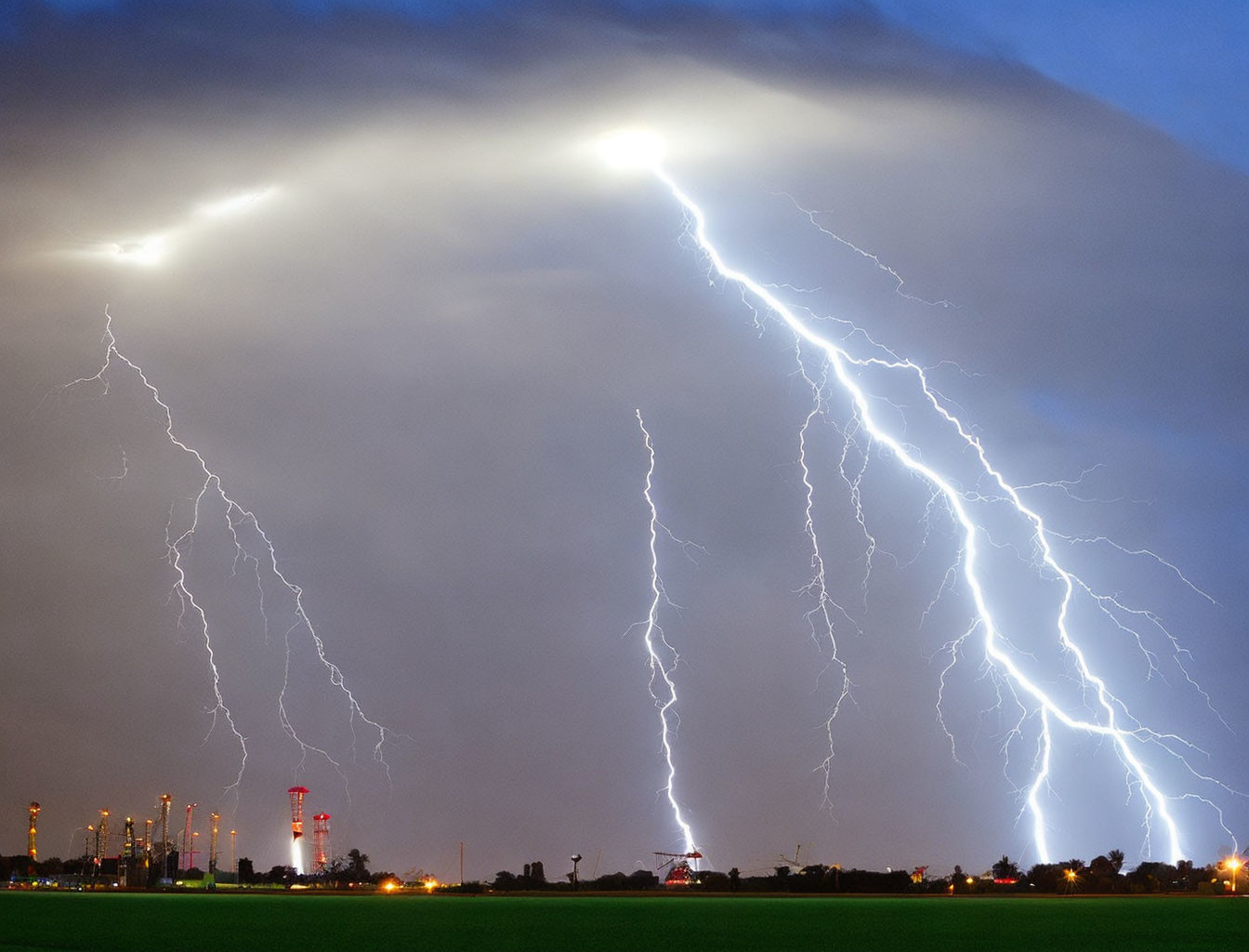 Dramatic lightning strike over industrial area at night