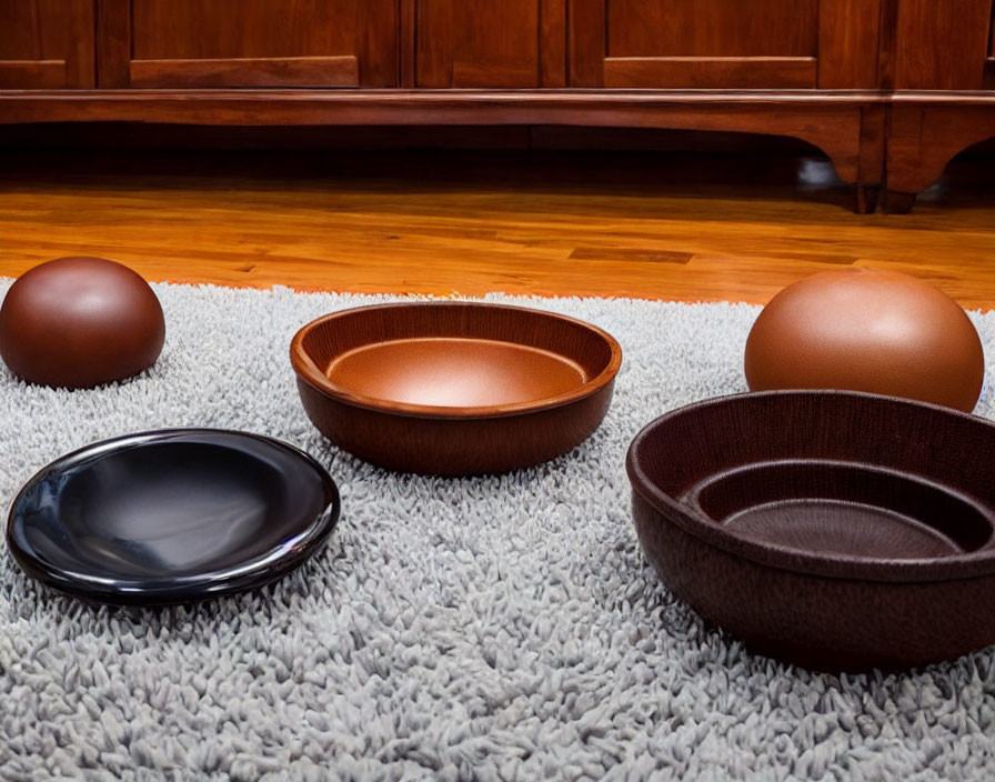 Varying Sizes and Colors Decorative Bowls on Grey Rug and Wooden Cabinet