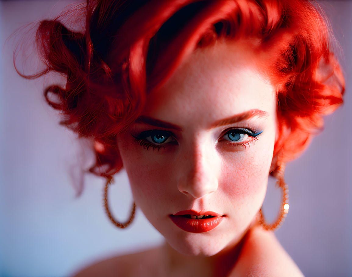 Vibrant red-haired woman with blue eyes and red lipstick portrait.