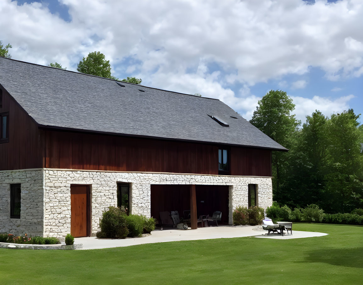 Stone foundation, dark wood siding, large windows: Modern barn-style house.