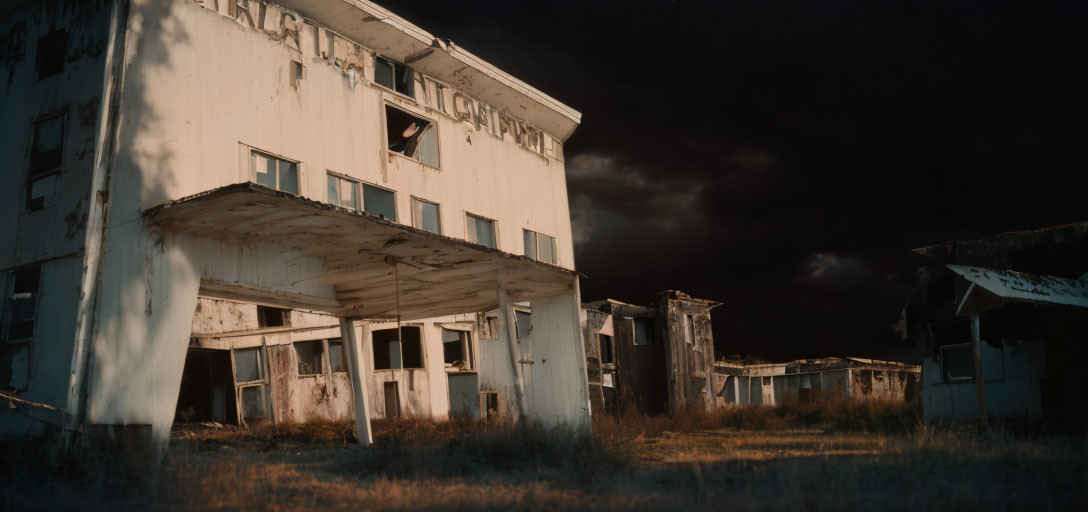 Abandoned building with broken windows under dark sky