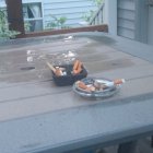 Wooden outdoor table with dry leaves and lit candle in glass lantern