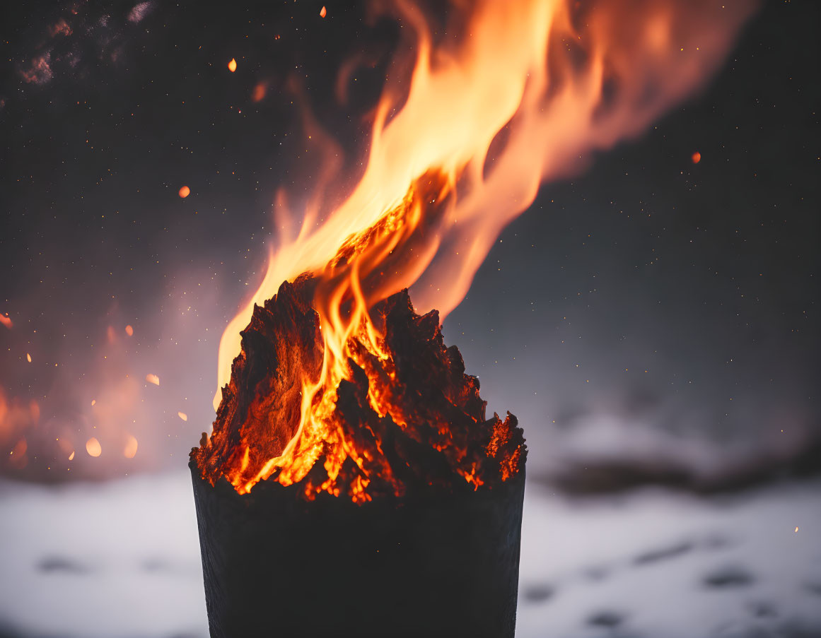 Fiery blaze on stump with embers in snowy landscape