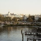 Tranquil riverfront scene with boats, pier, and autumn foliage