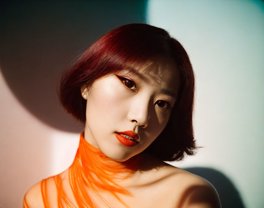 Red-Haired Woman in Bright Orange Attire Contemplating in Light and Shadow