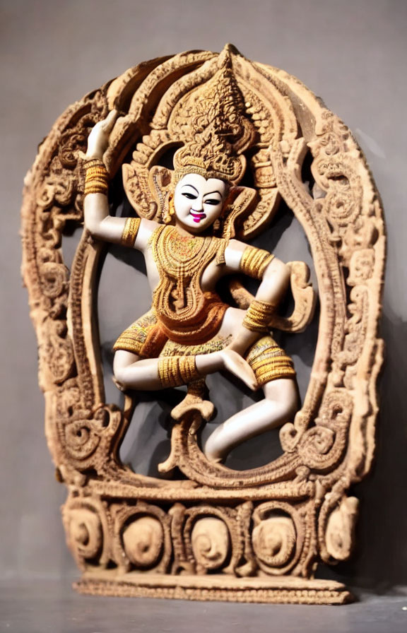 Intricate four-armed dancing figure in ornate headgear and costume within decorative frame