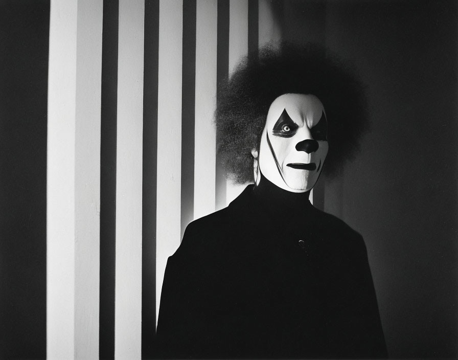 Black and white clown face paint with afro hairstyle against striped background