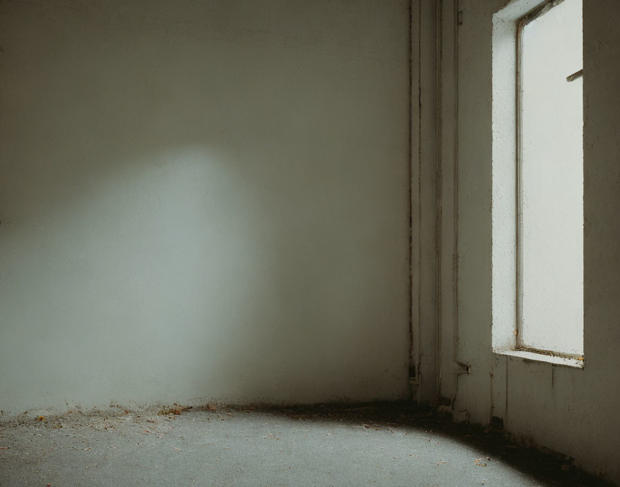 Desolate corner with closed white door and shadow on beige wall