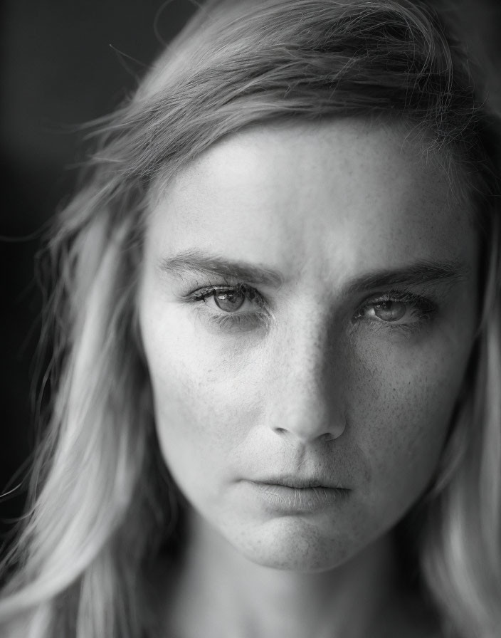 Monochrome close-up of woman with intense gaze and tousled hair