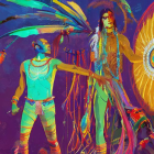 Two individuals in Native American headdresses against cosmic backdrop with dreamcatcher