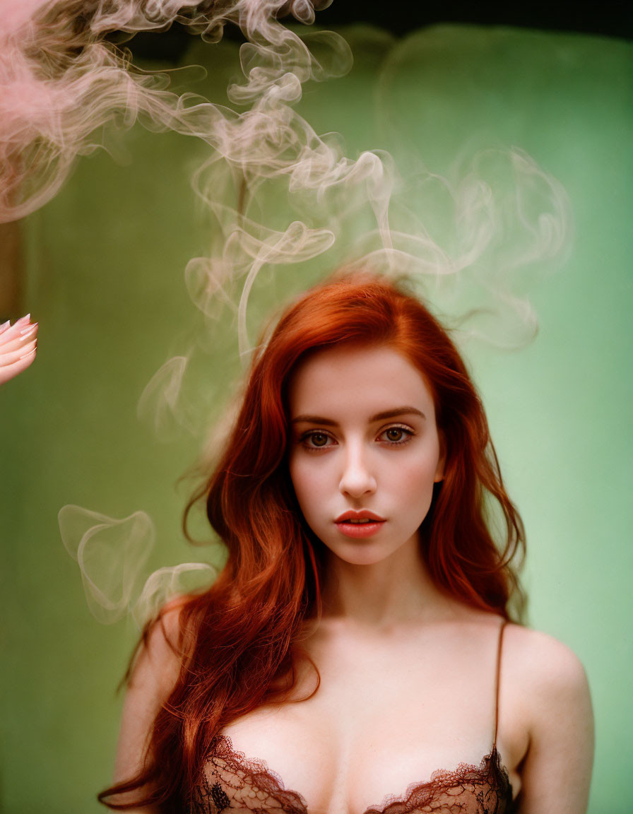 Red-haired woman in wistful expression amid swirling smoke on soft green backdrop