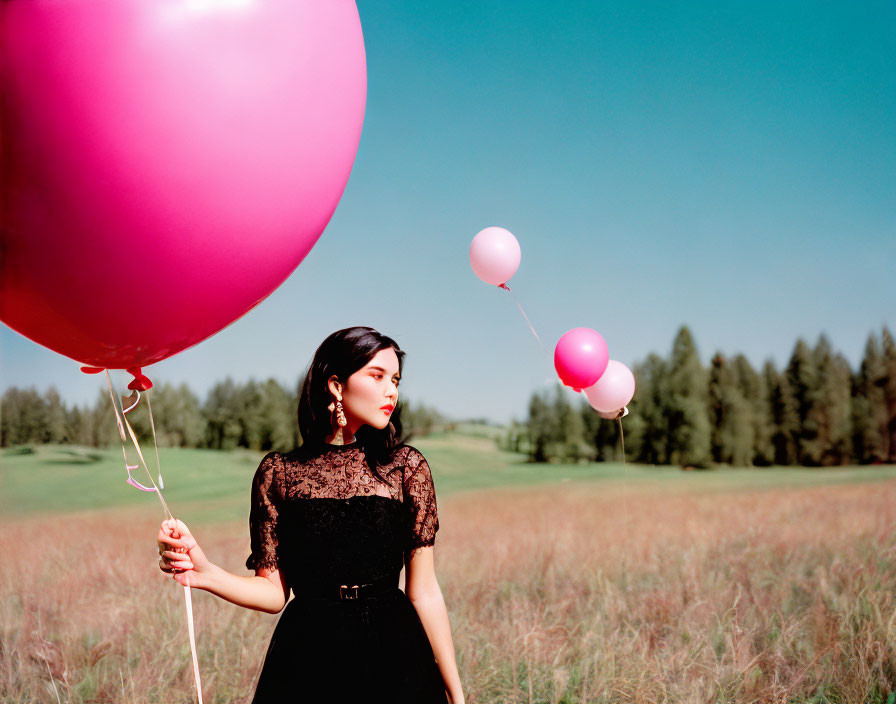 Woman in Black Dress with Pink Balloons in Field with Trees