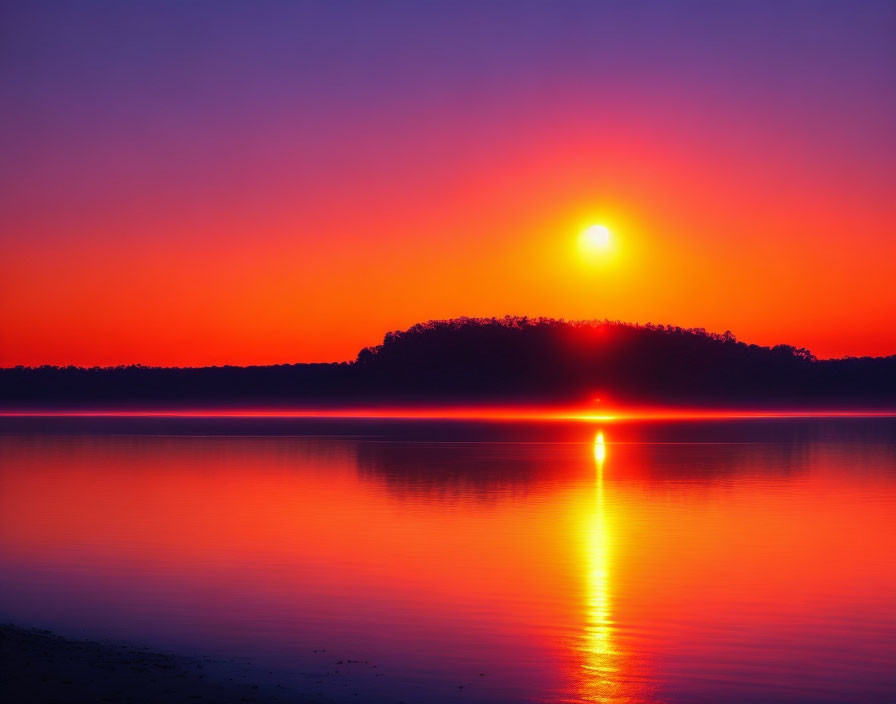 Scenic sunset over calm lake with purple-orange sky and hill silhouette