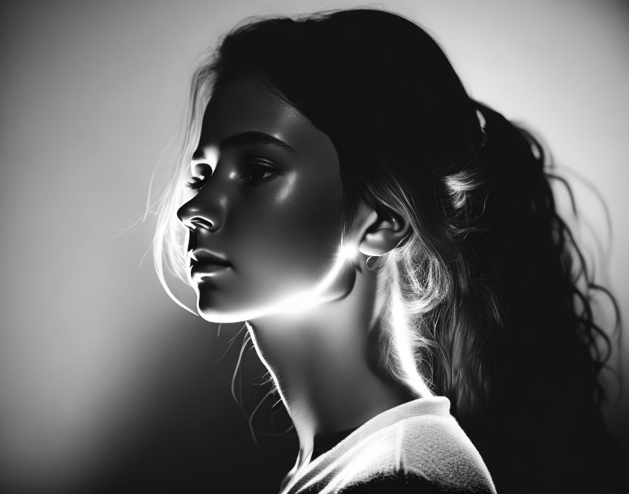 Monochrome profile portrait of woman with dramatic side lighting