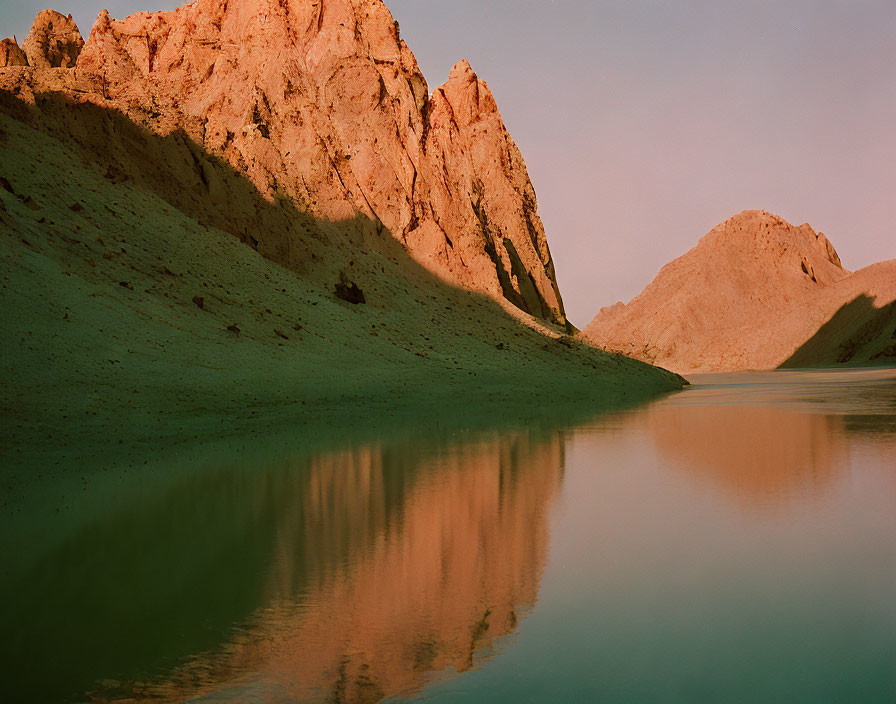 Sunlit Lake Reflects Rugged Mountain Shadows