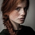 Young girl portrait with wavy brown hair in green dress.