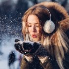 Woman in Hooded Coat Surrounded by Colorful Snowflakes