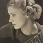 Vintage-style portrait of woman in pilot's attire with wavy hair and elegant aura