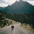 Couple embracing on deserted road with mountains and cloudy sky