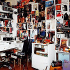 Cluttered room with memorabilia, electronics, photos, and posters.