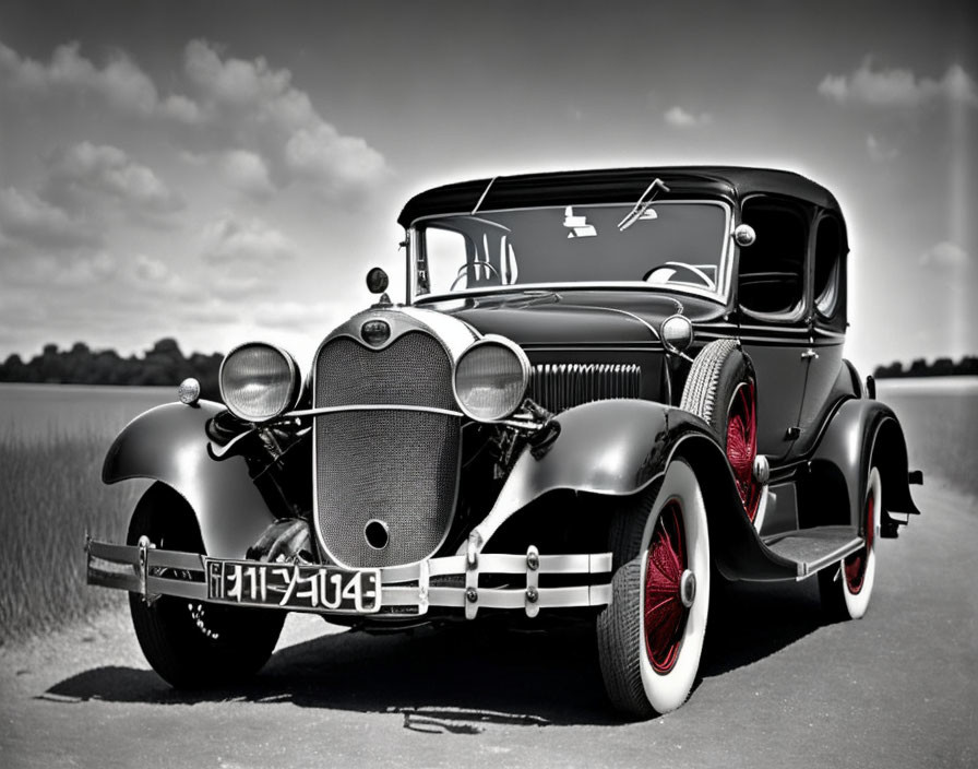 Vintage Black Car with Red-Rimmed Wheels on Flat Surface Under Cloudy Sky